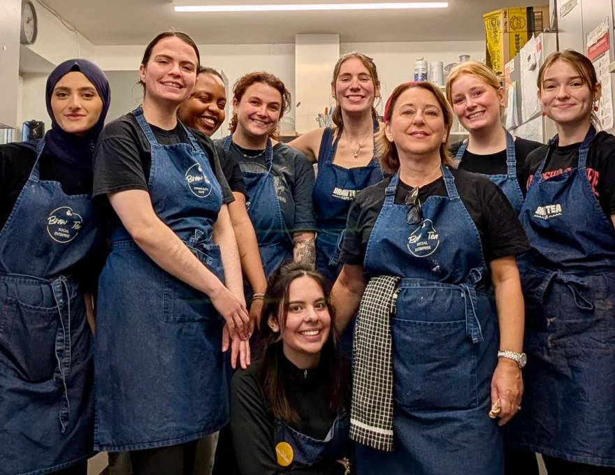 Staff and volunteers at Braw Tea social enterprise wearing branded aprons in their kitchen